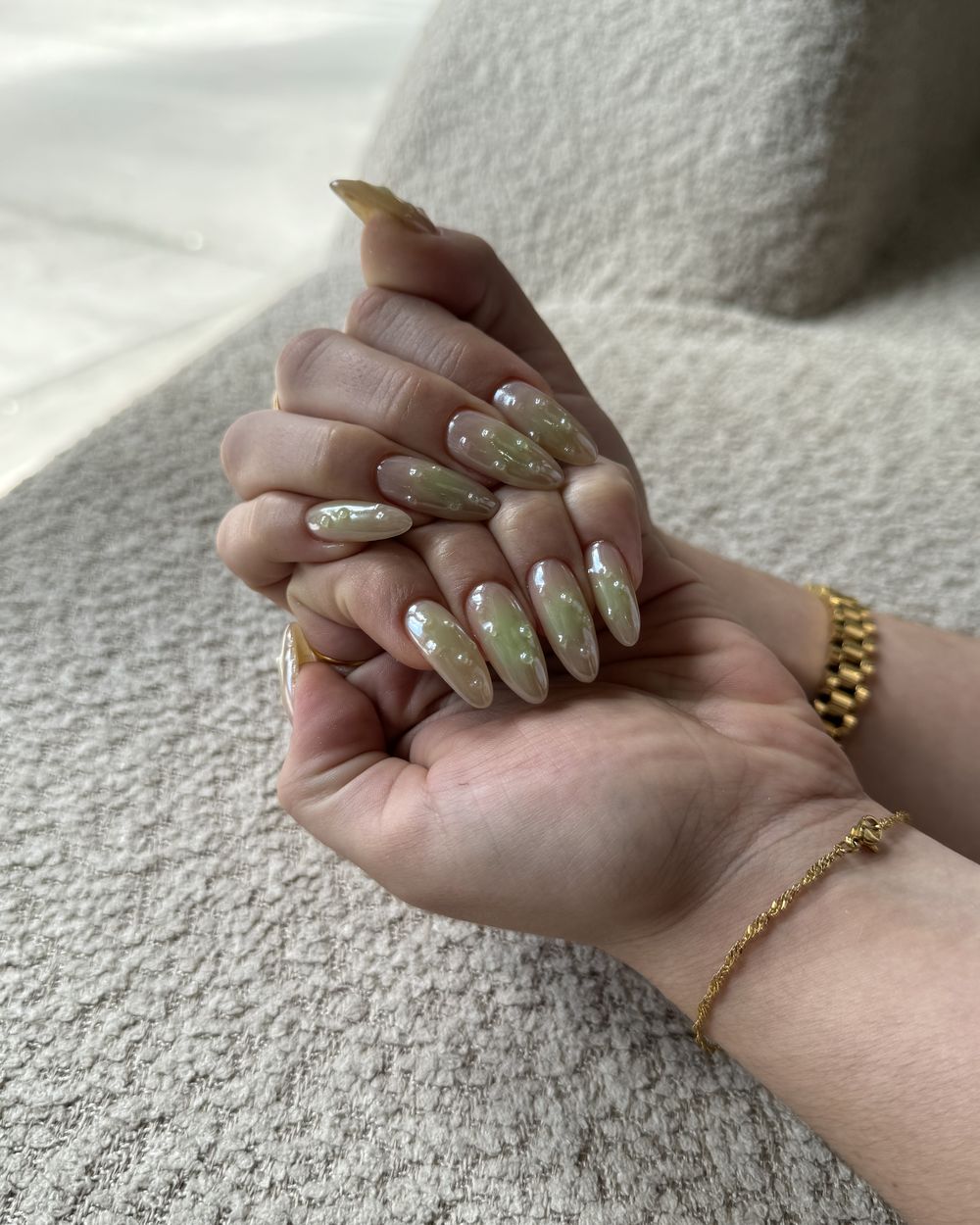 A sage and gold-flake manicure in open hands