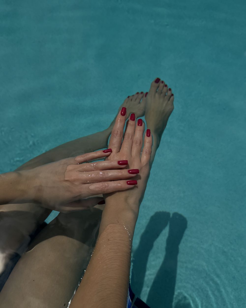 Red nails and toes in turquoise water